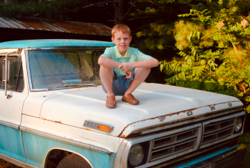 meredith pritchard boy posed on top of a truck